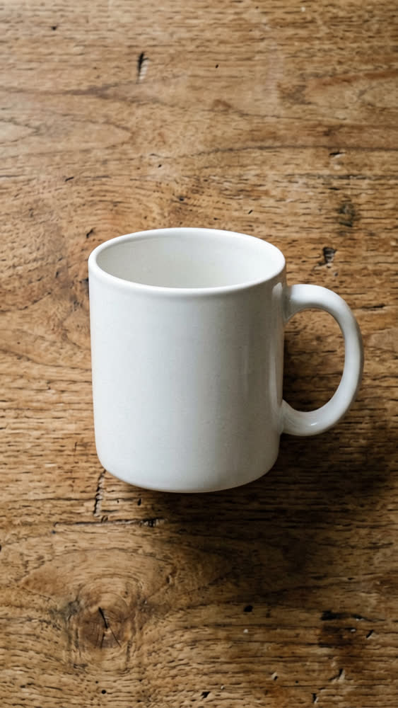 Produktfoto einer weißen Tasse auf einem Holztisch