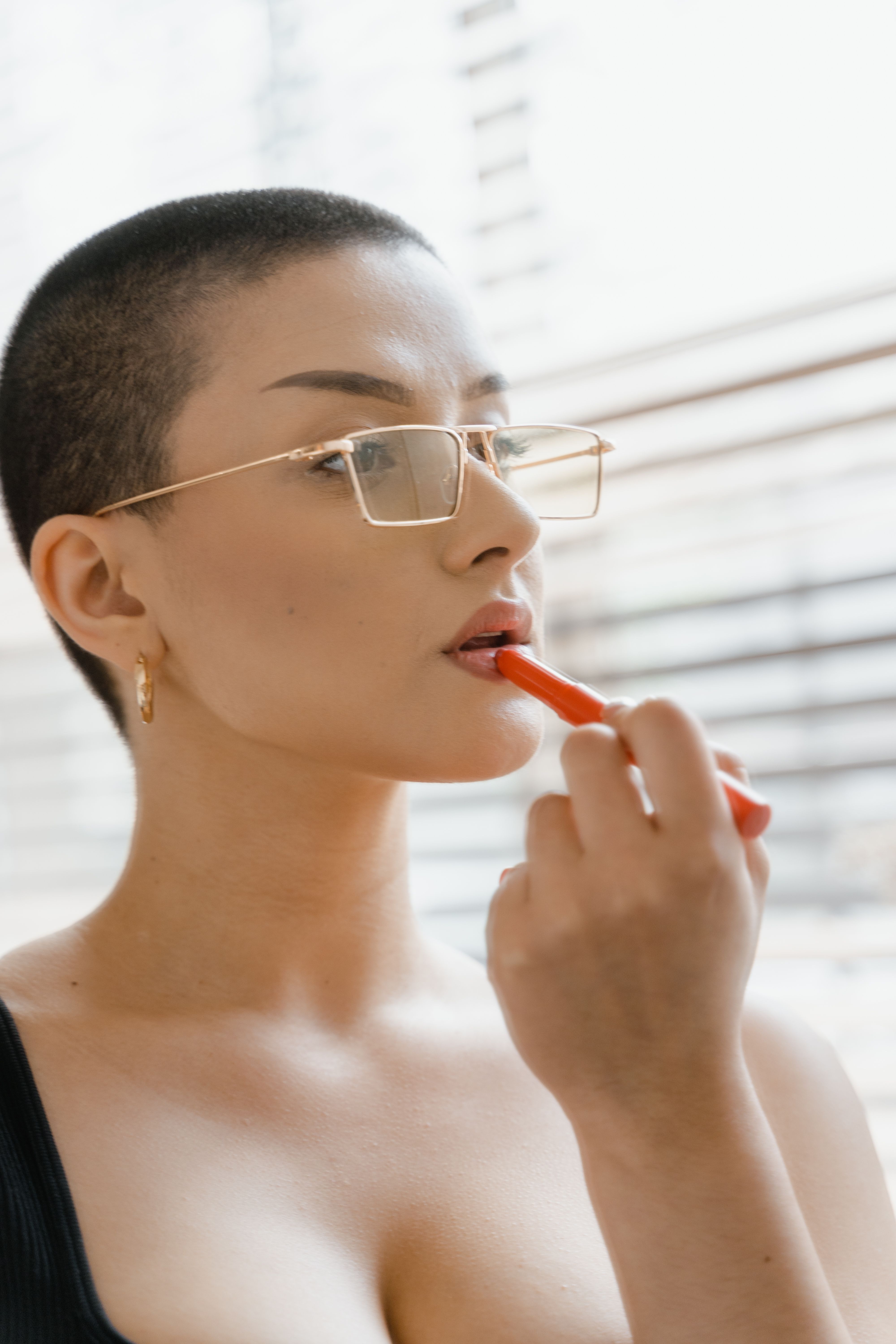 Original photo of a person applying lipstick